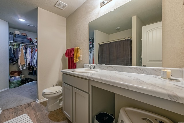 bathroom featuring a shower with shower curtain, wood-type flooring, vanity, and toilet