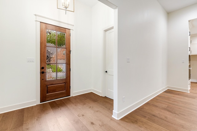 entrance foyer featuring light hardwood / wood-style flooring and an inviting chandelier