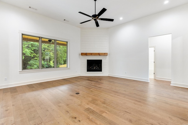 unfurnished living room featuring a fireplace, light hardwood / wood-style flooring, and ceiling fan