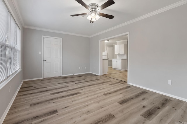 empty room featuring a wealth of natural light, light hardwood / wood-style flooring, ceiling fan, and ornamental molding