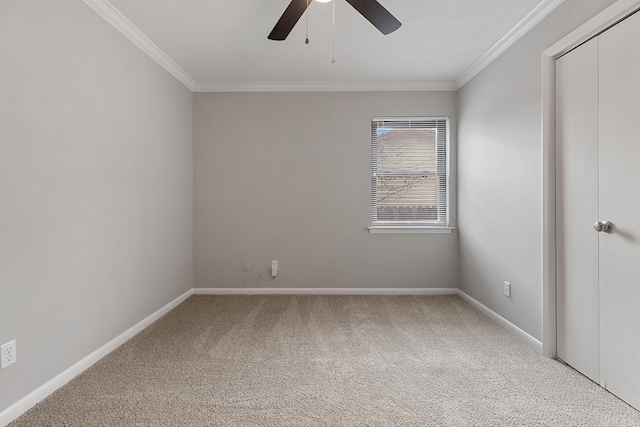 spare room featuring carpet, ceiling fan, and crown molding