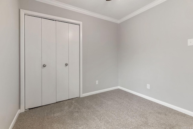 unfurnished bedroom with crown molding, a closet, and carpet