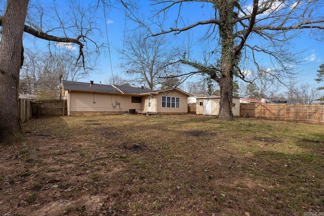 rear view of house featuring a lawn and central AC unit