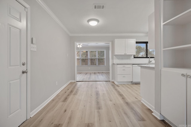 interior space with a wealth of natural light, crown molding, and light hardwood / wood-style floors