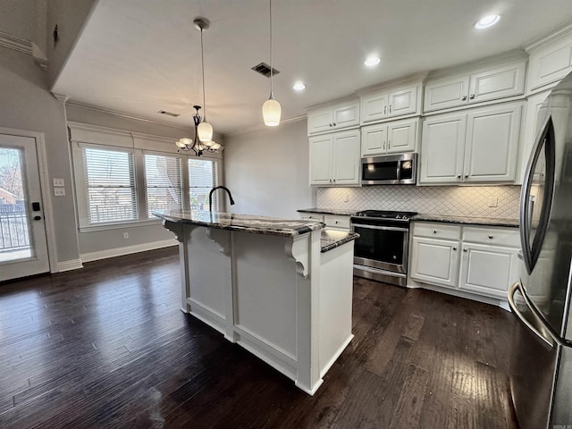 kitchen featuring pendant lighting, white cabinetry, a kitchen island with sink, and appliances with stainless steel finishes