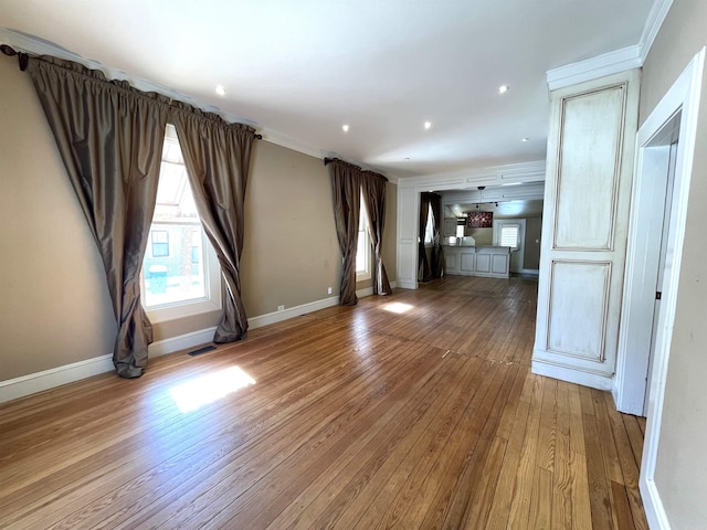 unfurnished living room with ornamental molding and hardwood / wood-style flooring