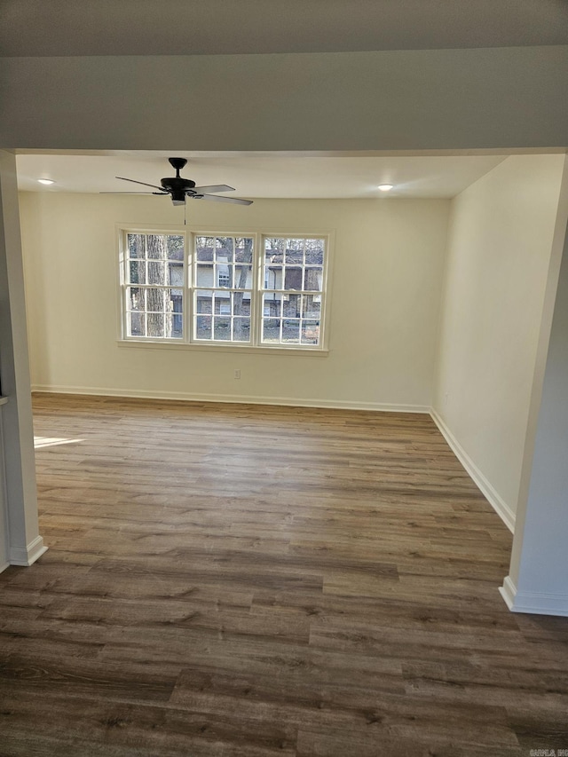 empty room with ceiling fan and dark hardwood / wood-style flooring