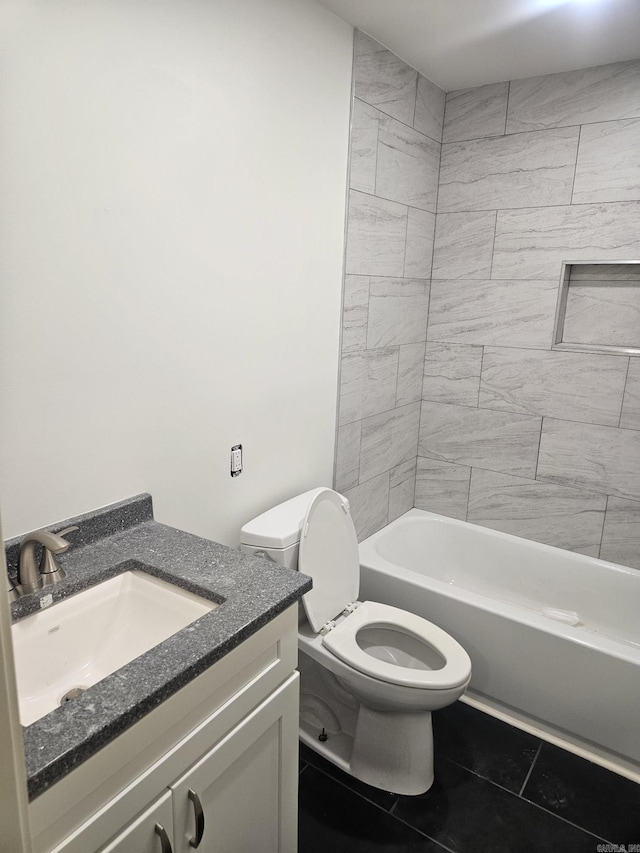 full bathroom with tiled shower / bath, tile patterned flooring, vanity, and toilet