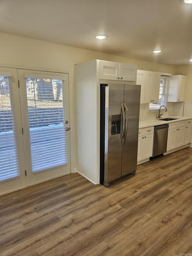 kitchen with dark hardwood / wood-style flooring, sink, white cabinets, and appliances with stainless steel finishes