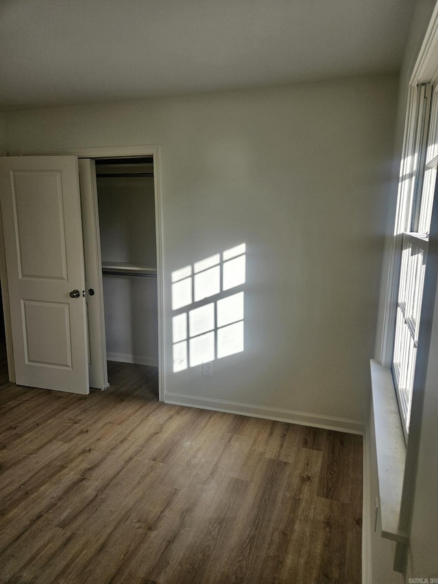 unfurnished bedroom with hardwood / wood-style floors and a closet