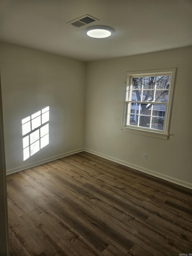 spare room with dark hardwood / wood-style floors