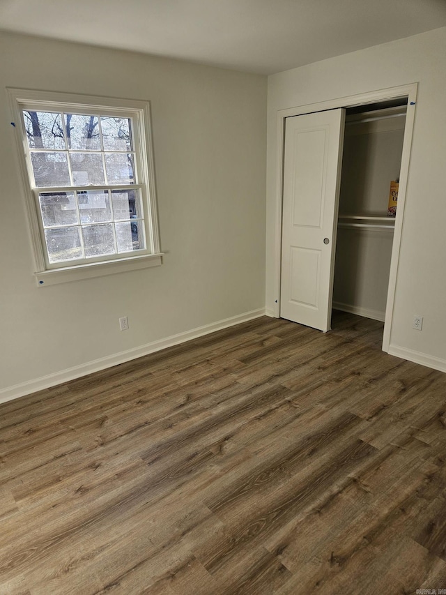 unfurnished bedroom with a closet and dark wood-type flooring