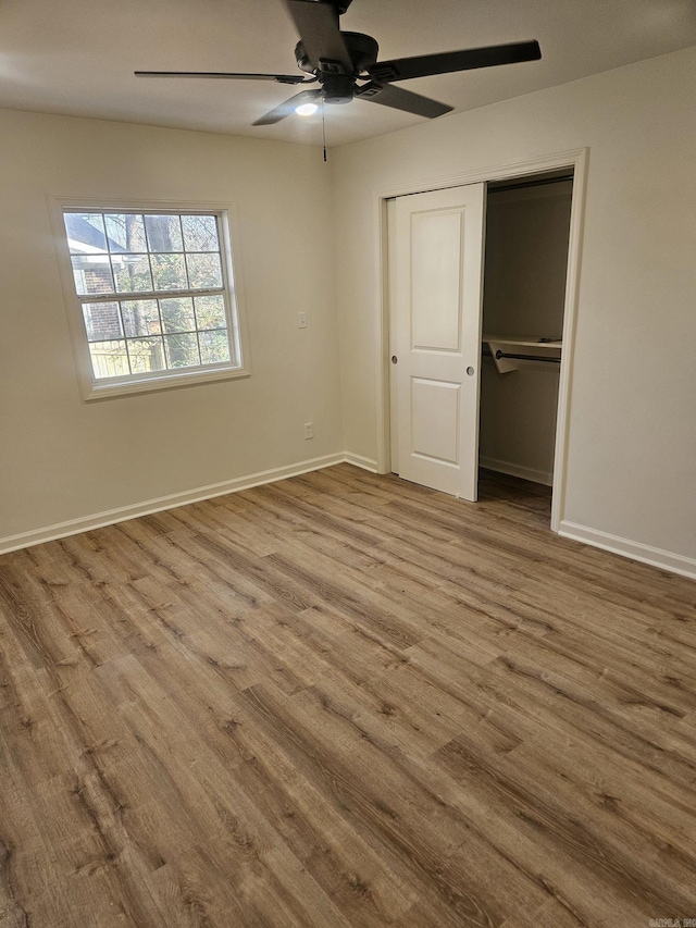 unfurnished bedroom featuring ceiling fan, light hardwood / wood-style floors, and a closet