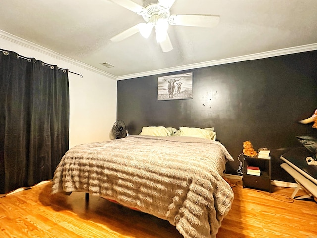 bedroom with wood-type flooring, ceiling fan, and crown molding