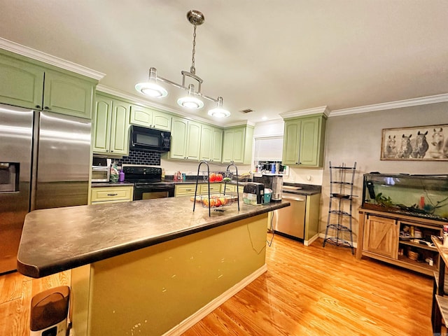 kitchen with black appliances, light hardwood / wood-style floors, a kitchen island, hanging light fixtures, and a breakfast bar area