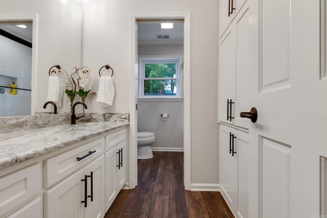 bathroom with hardwood / wood-style floors, vanity, toilet, and ornamental molding