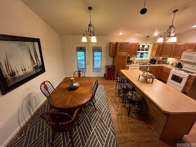 dining room featuring a chandelier, vaulted ceiling, and dark wood-type flooring