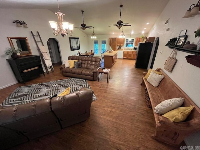 living room with hardwood / wood-style floors, ceiling fan with notable chandelier, and vaulted ceiling