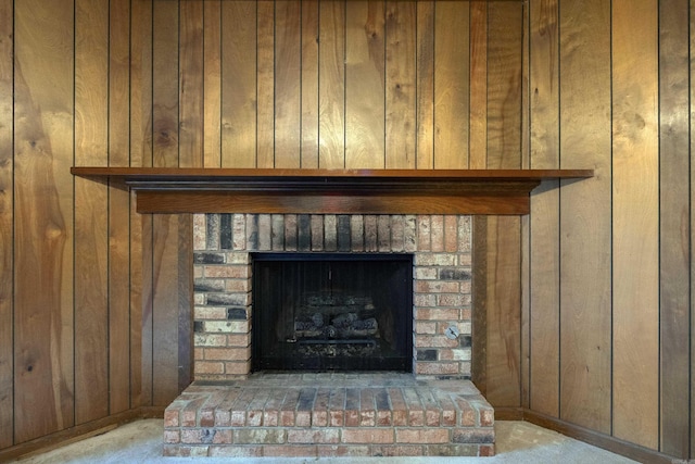 interior details with a fireplace, carpet floors, and wood walls