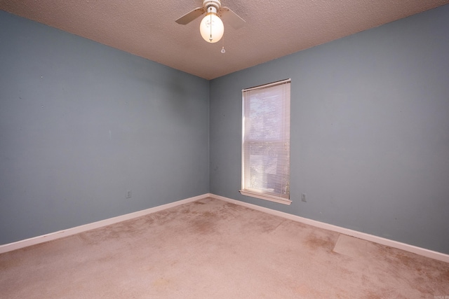 carpeted spare room with ceiling fan and a textured ceiling