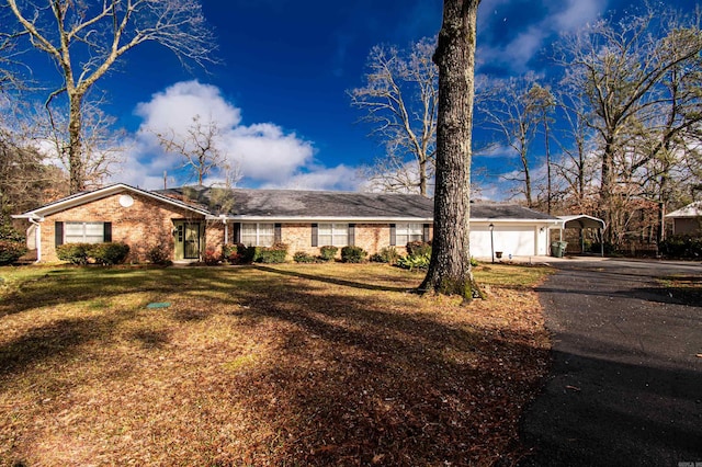 ranch-style home featuring a front lawn, a garage, and a carport