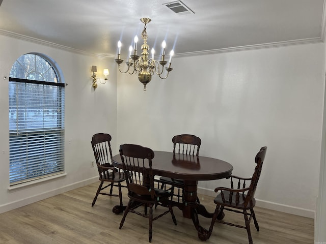 dining room with ornamental molding, light hardwood / wood-style floors, and a chandelier