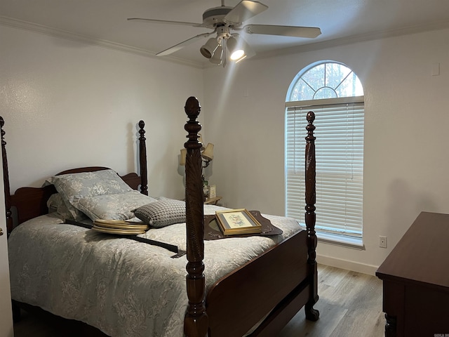 bedroom featuring crown molding, light hardwood / wood-style flooring, and ceiling fan