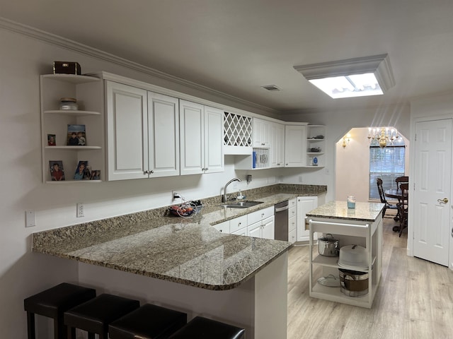 kitchen featuring sink, kitchen peninsula, and light stone countertops