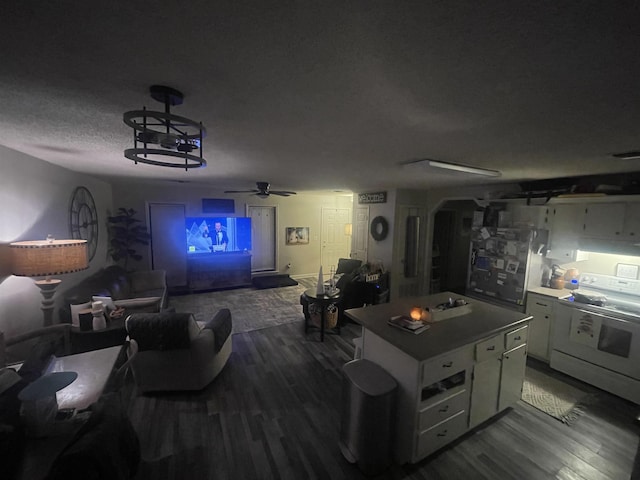 cinema featuring ceiling fan, dark hardwood / wood-style floors, and a textured ceiling