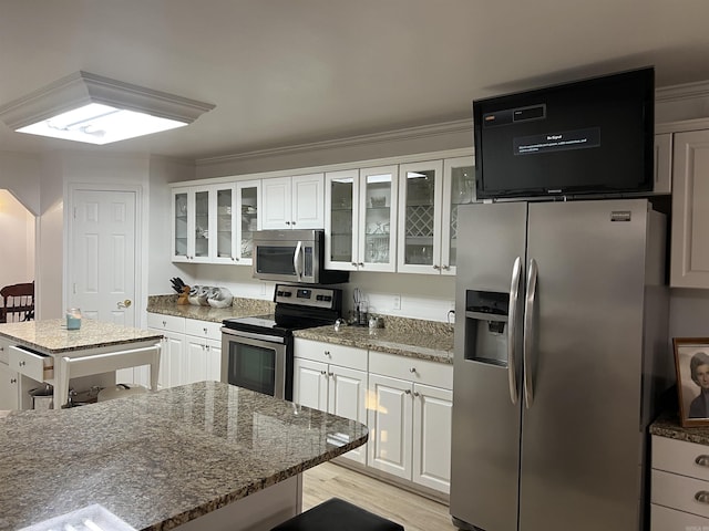 kitchen with crown molding, appliances with stainless steel finishes, and white cabinets