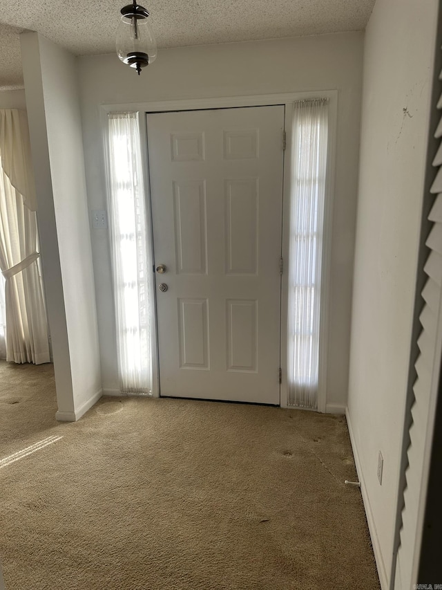 foyer entrance featuring carpet and a textured ceiling