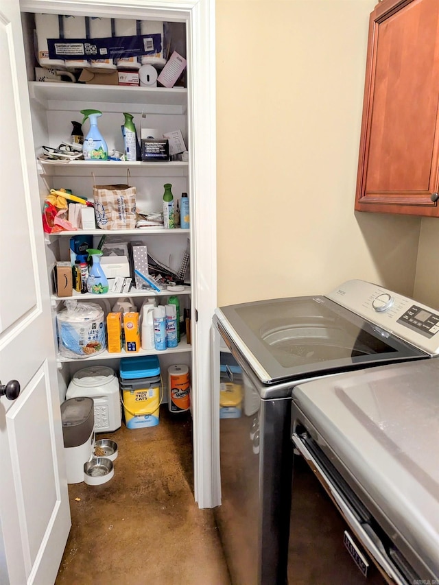 clothes washing area with washer and dryer and cabinets