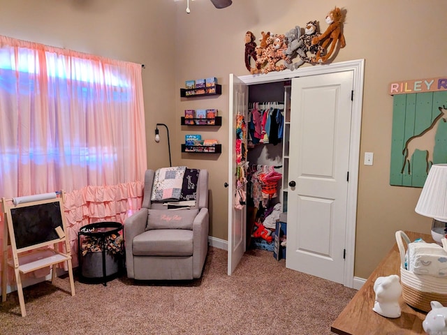 living area featuring light carpet and ceiling fan