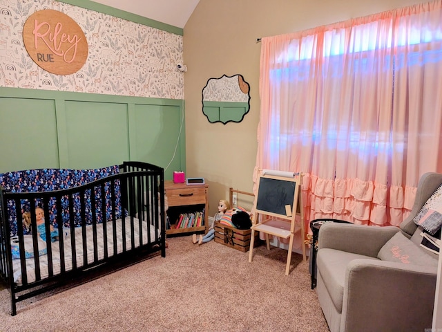 bedroom featuring a nursery area, light carpet, and vaulted ceiling