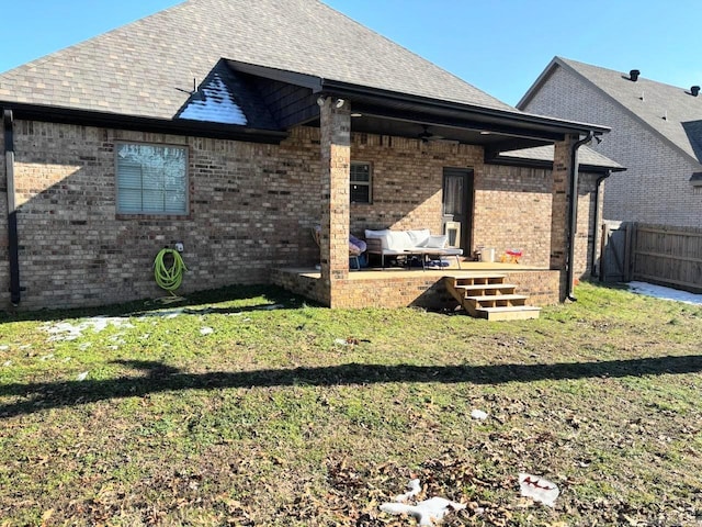 rear view of house with a lawn and ceiling fan