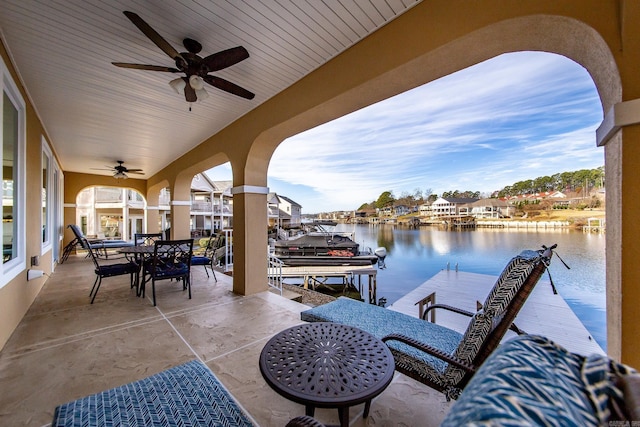 view of patio / terrace featuring ceiling fan, a water view, and a dock