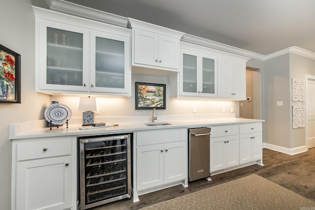 bar with white cabinetry, wine cooler, crown molding, and sink