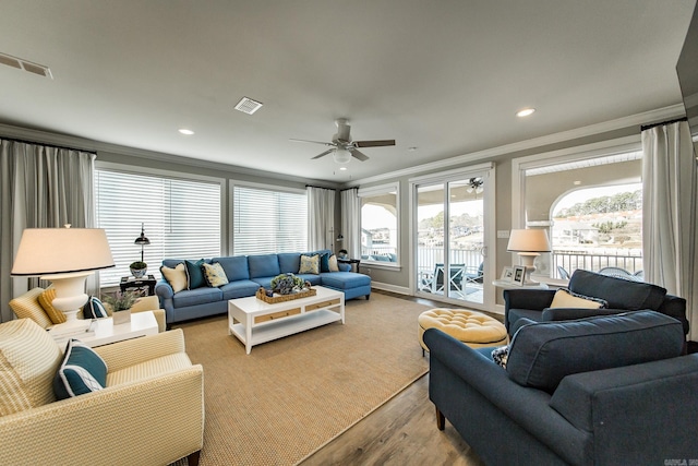 living room with light hardwood / wood-style floors, ceiling fan, and ornamental molding