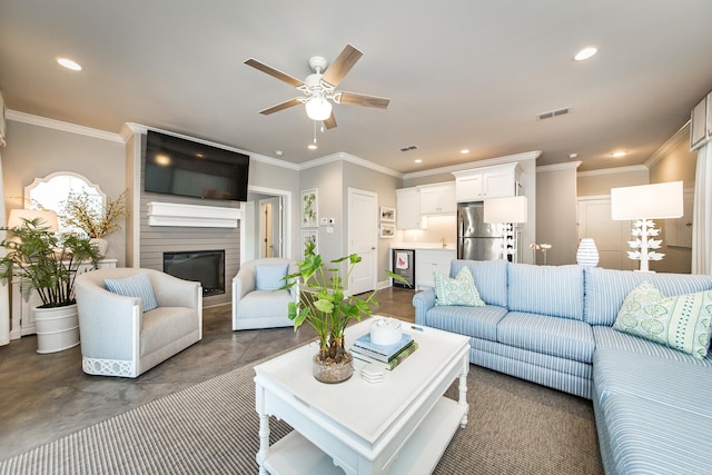 living room with ceiling fan, a large fireplace, and crown molding