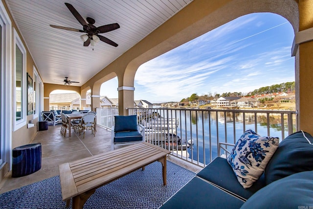 balcony with ceiling fan, a water view, and an outdoor hangout area