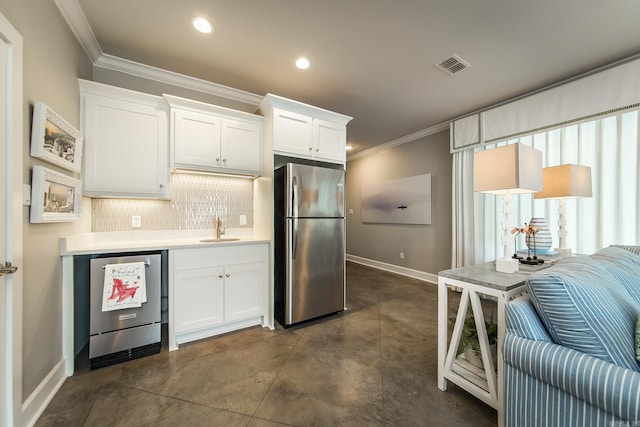 kitchen featuring sink, crown molding, decorative backsplash, white cabinets, and appliances with stainless steel finishes