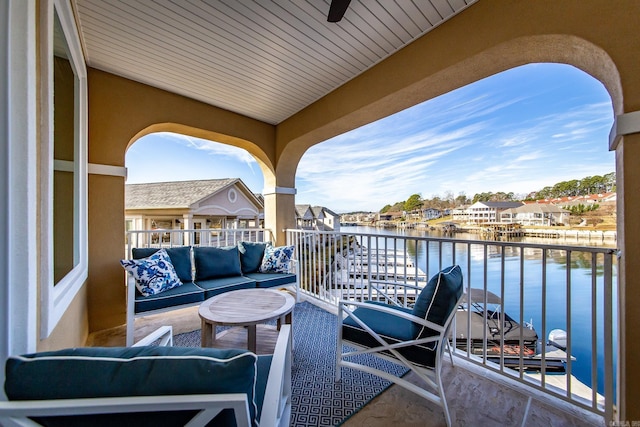 balcony featuring an outdoor living space, a water view, and ceiling fan