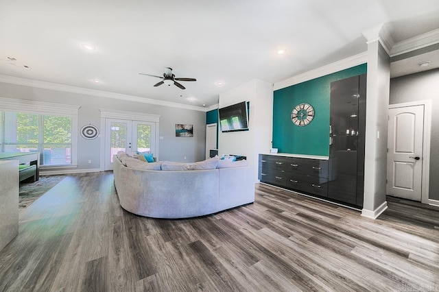 living room featuring wood-type flooring, french doors, ornamental molding, and ceiling fan