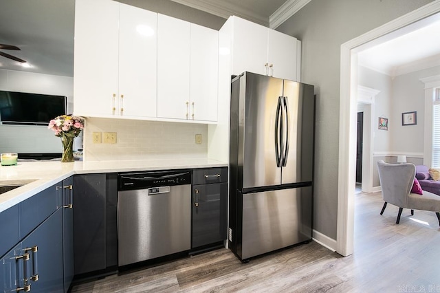 kitchen featuring blue cabinets, white cabinets, and appliances with stainless steel finishes