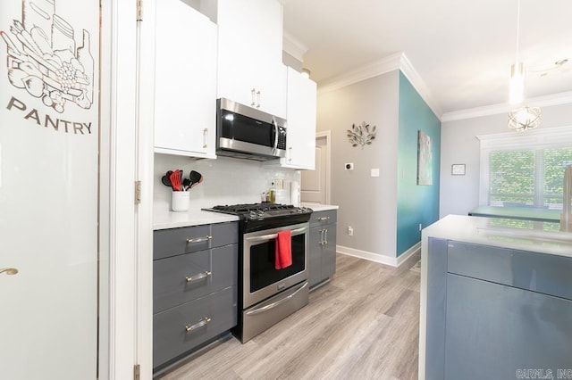 kitchen with pendant lighting, backsplash, white cabinets, light hardwood / wood-style flooring, and stainless steel appliances