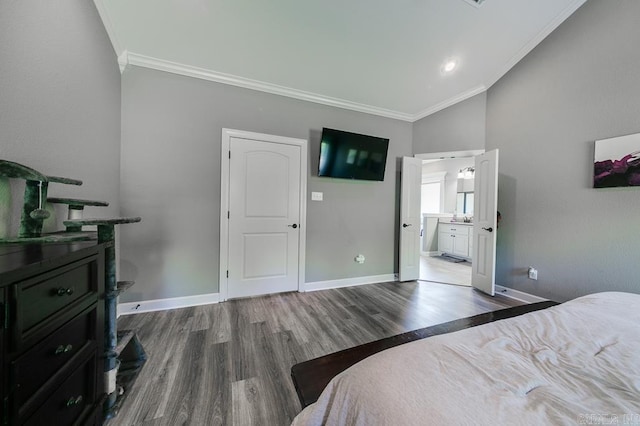 bedroom featuring hardwood / wood-style flooring, vaulted ceiling, ornamental molding, and ensuite bathroom