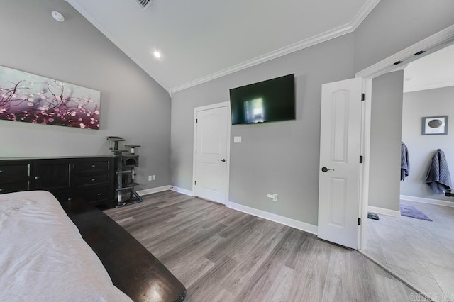 bedroom with hardwood / wood-style floors, ornamental molding, and vaulted ceiling