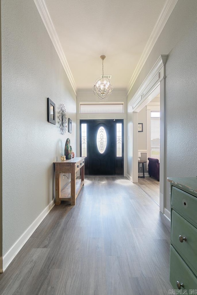 entrance foyer with crown molding, dark wood-type flooring, and an inviting chandelier