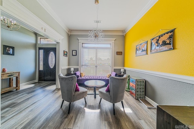 dining area with wood-type flooring, a chandelier, and ornamental molding