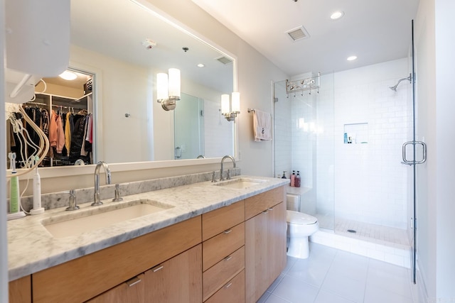 bathroom featuring tile patterned flooring, vanity, toilet, and an enclosed shower